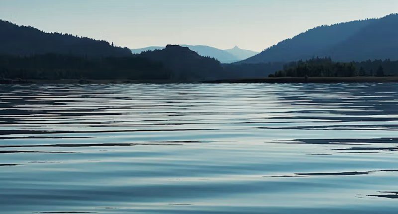 Still water at dusk with distant hills